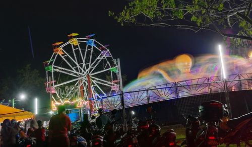 Low angle view of illuminated ferris wheel at night