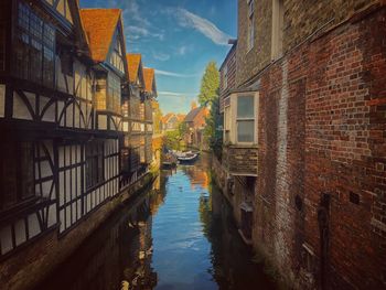 Canal amidst buildings against sky