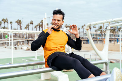 Young man exercising on gymnastics bar