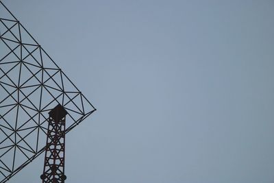 Low angle view of electricity pylon against clear sky