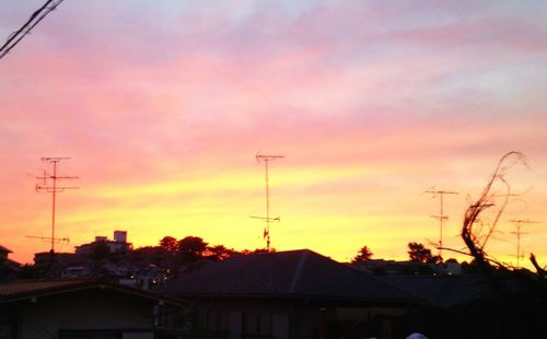 Low angle view of houses against sky at sunset