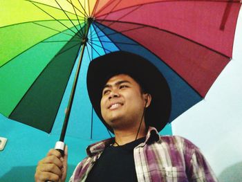 Portrait of smiling young man standing in rain