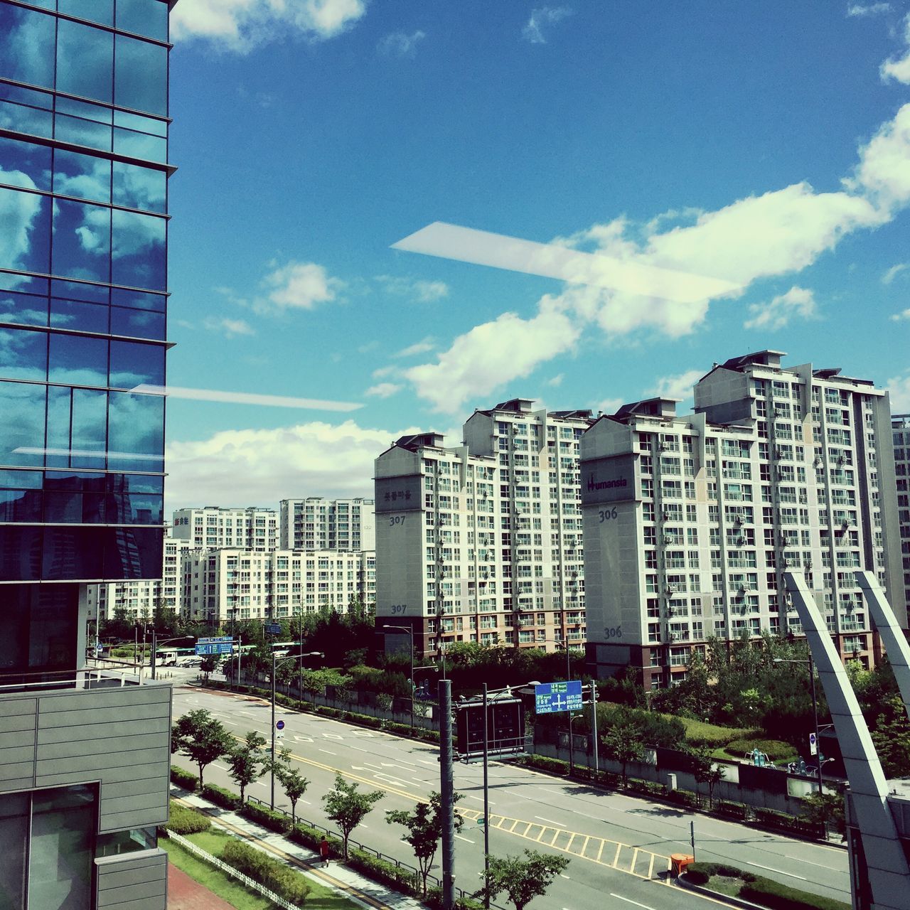 building exterior, architecture, built structure, city, sky, street, transportation, road, car, building, cloud - sky, city life, cloud, residential building, modern, office building, cityscape, day, land vehicle, skyscraper