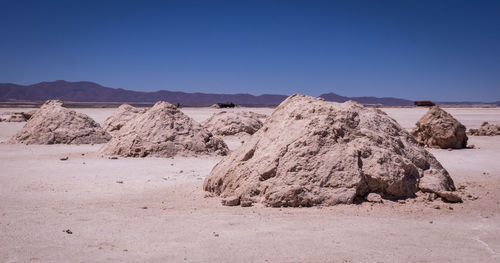 Rock formations in desert against clear blue sky