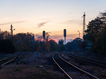 Train on railroad tracks against sky during sunset