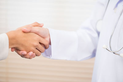 Doctor and patient shaking hands in hospital