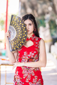 Midsection of woman holding red umbrella