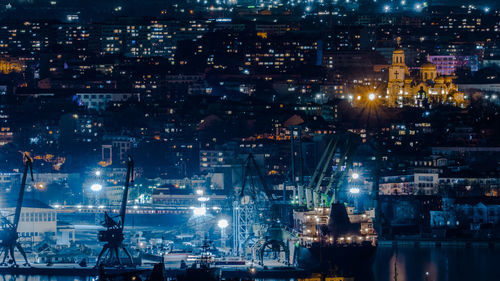 Illuminated cityscape against sky at night