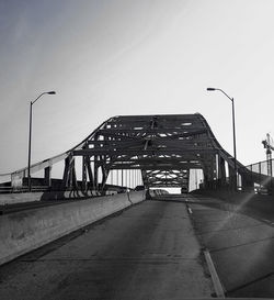 Road leading towards city against clear sky