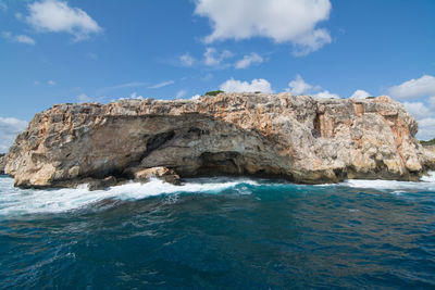 Rock formations by sea against sky