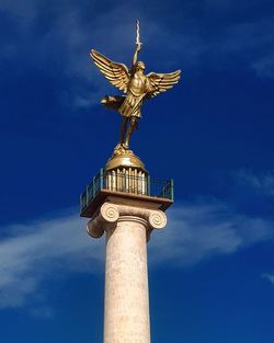 Low angle view of statue against blue sky