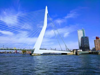 Bridge over river against sky in city