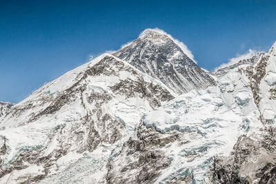 Scenic view of snowcapped mountains against blue sky