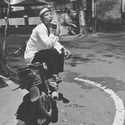 Man riding bicycle on road in city