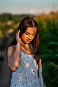 Young woman standing against plants