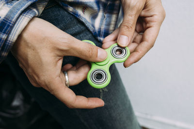 Midsection of man holding fidget spinner 