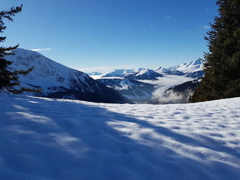 Scenic view of snow mountains against blue sky