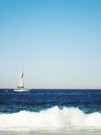 Sailboat sailing in sea against clear sky