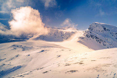 Scenic view of snow covered mountains against sky