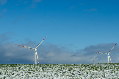Low angle view of windmill against clear blue sky