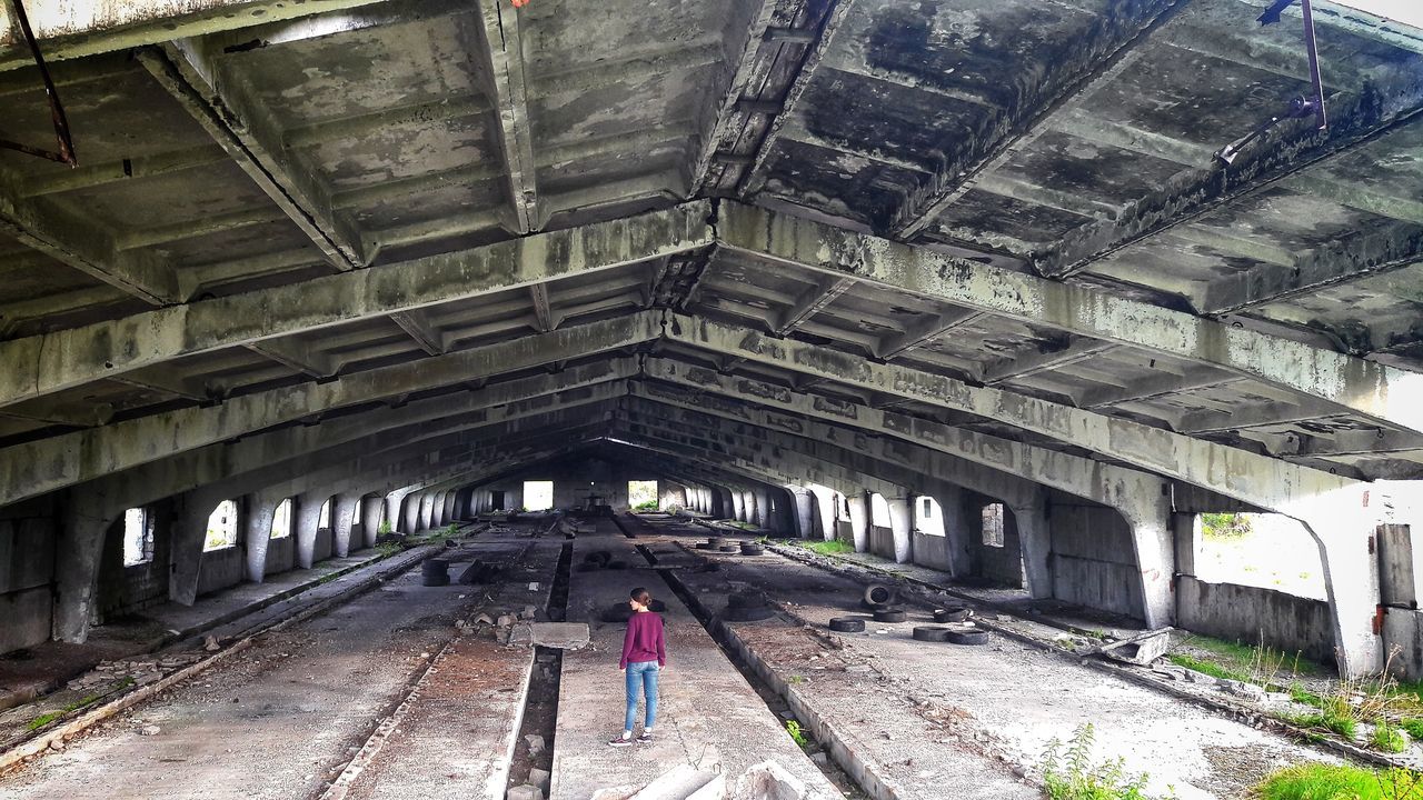 WOMAN STANDING ON ABANDONED BUS