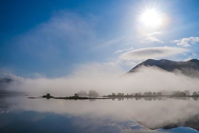 Scenic view of lake by mountains against sky