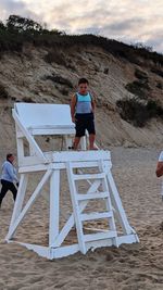 Full length of men standing at beach against sky