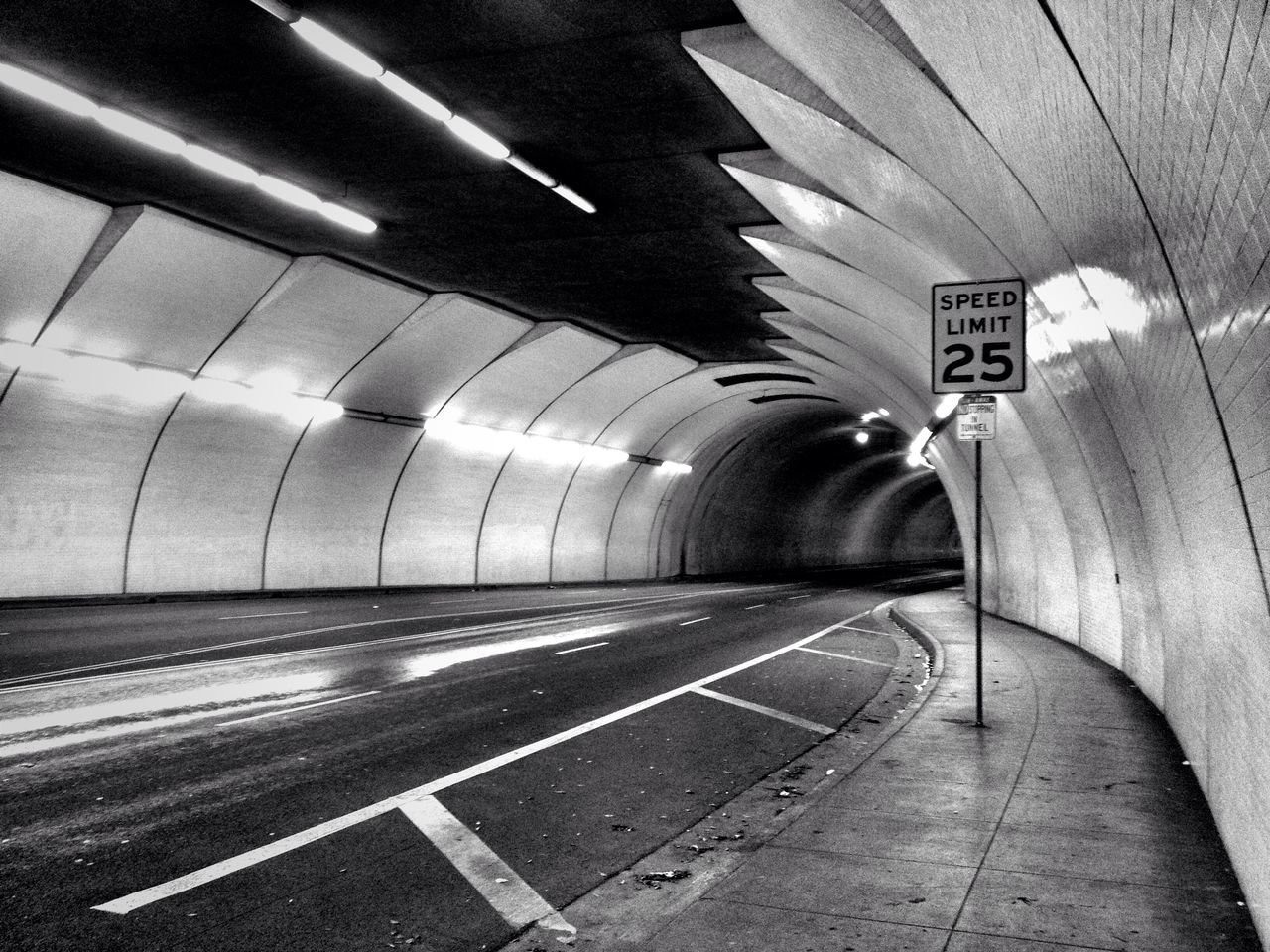 transportation, the way forward, road marking, diminishing perspective, road, vanishing point, guidance, tunnel, arrow symbol, empty, communication, asphalt, illuminated, direction, text, travel, information sign, indoors, dividing line, directional sign