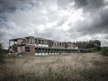 Built structure on field against cloudy sky