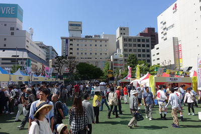 People on street against buildings in city