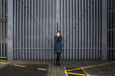 Full length of woman standing in front of building