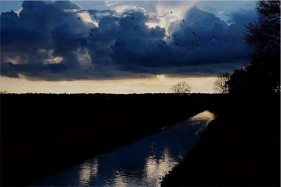 Scenic view of lake against cloudy sky
