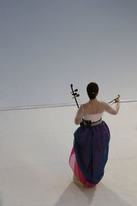 Rear view of woman standing against sky