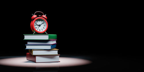 Close-up of clock on table against black background