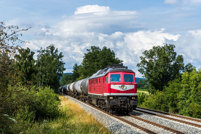 Train by railroad tracks against sky