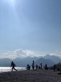 People enjoying at beach against sky