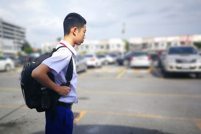 Boy standing on road in city