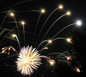 Low angle view of firework display at night