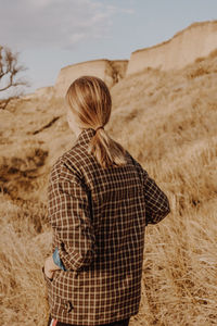 Rear view of woman standing on land against sky