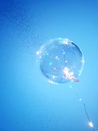 Low angle view of bubbles in sea against clear blue sky