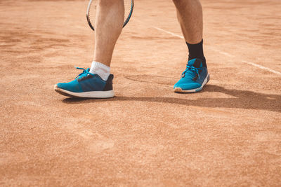 Low section of man standing on playing field