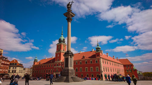 Group of people in front of building against blue sky kolumna zygmunta palace 