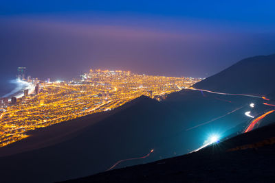 Aerial view of illuminated cityscape against sky at night