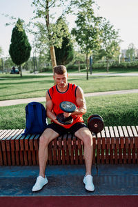 Portrait of young man sitting on bench