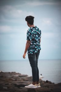 Man standing at beach against sky