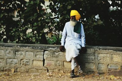 Senior man sitting on retaining wall