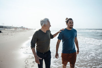 Rear view of couple standing at beach