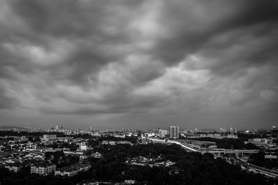 Aerial view of cityscape against storm clouds