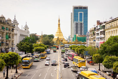 Traffic on road amidst buildings in city against sky