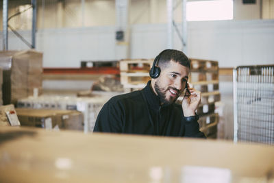 Male manual worker talking through headset at logistics warehouse
